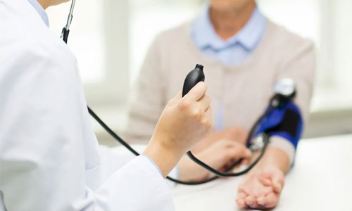 A doctor is holding a phone and listening to someone