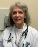 A woman in white coat with stethoscope around neck.